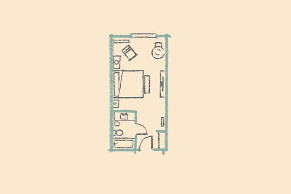 A small, rectangular floor plan showing a bedroom with a bed, desk, chair, small kitchen, bathroom, and storage space.