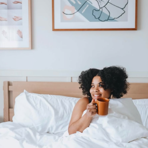 Two kids jump on a bed with joy in a bright, cozy bedroom, playful chaos, soft pastel walls, and framed art above.